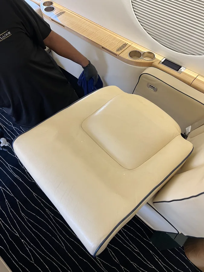 Aeroluxe leather-seat care in progress in a business-jet cabin.