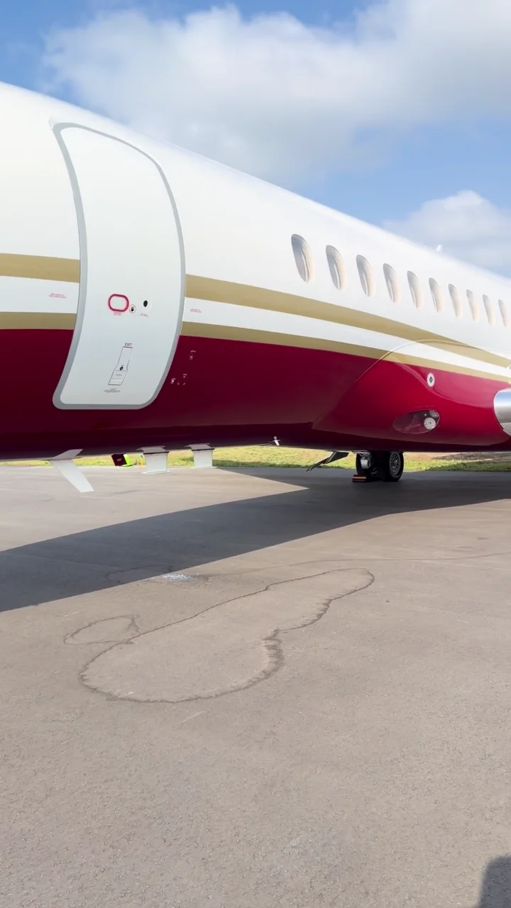 Red and gold Dassault Falcon tri-jet on the ramp.